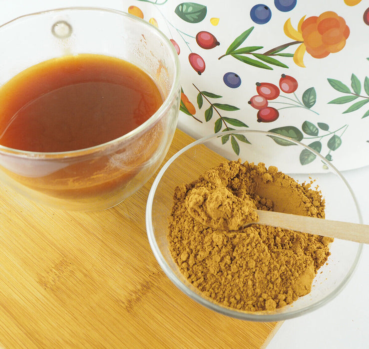 Poudre de Guarana brésilien prête à être mélangée pour une boisson énergisante, présentée sur une table en bois rustique.