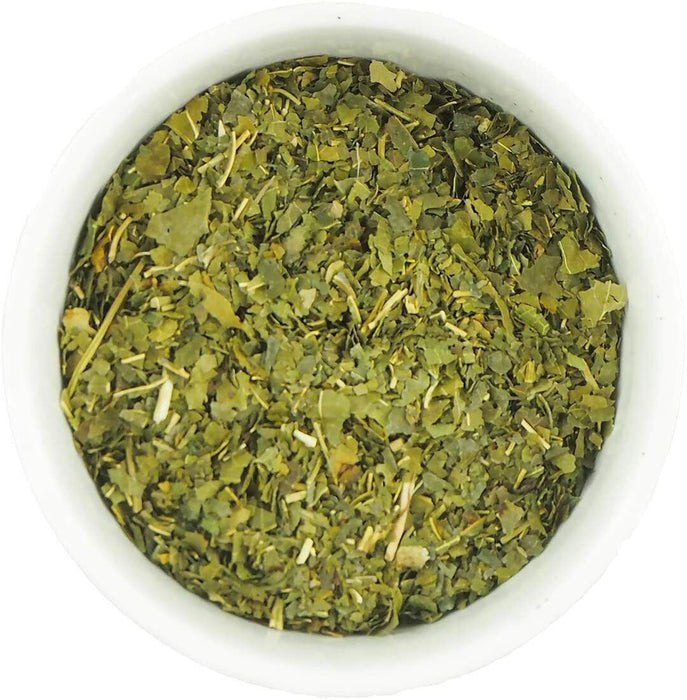 Feuilles de mûrier blanc séchées biologiques Morus alba dans un bol blanc, vue de dessus, pour une alimentation équilibrée.