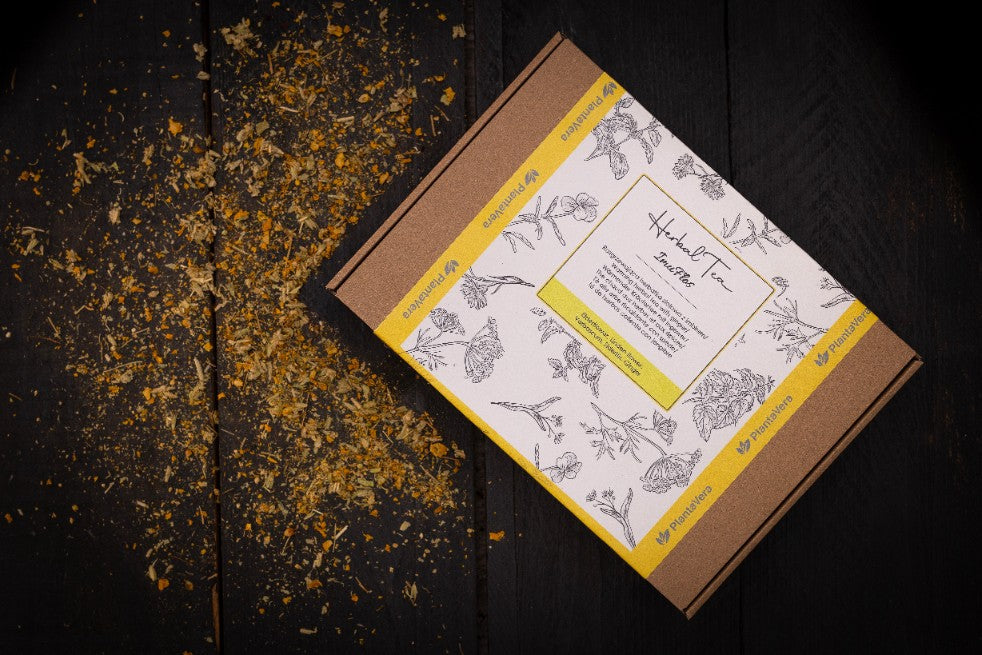 Dos de l'emballage Herbal Tea Immuflos avec instructions et informations en plusieurs langues sur fond jaune vibrant.