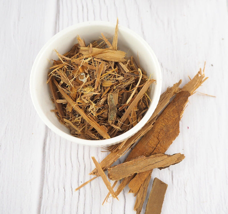 Écorce de Catuaba coupée dans un bol sur un fond blanc, évoquant la pureté et l'origine naturelle du produit.