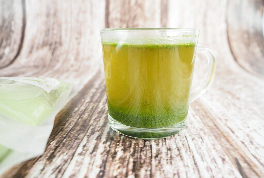 Infusion verte de feuilles de mûrier blanc dans une tasse transparente avec emballage.