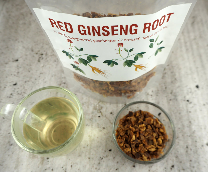 Infusion de racine de Ginseng rouge dans une tasse transparente, avec un paquet ouvert en arrière-plan, illustrant un mode de vie sain.