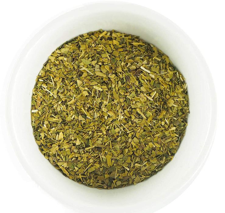 Yerba Mate brésilienne de qualité supérieure dans un bol blanc, montrant la couleur verte vive et fraîche de l'herbe séchée à l'air.