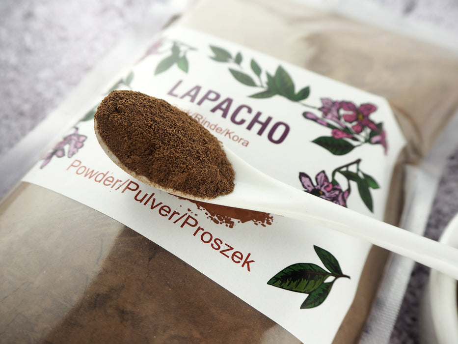 Cuillère de poudre de Lapacho au-dessus d'un sachet, prête pour la préparation d'une tisane robuste et réconfortante.