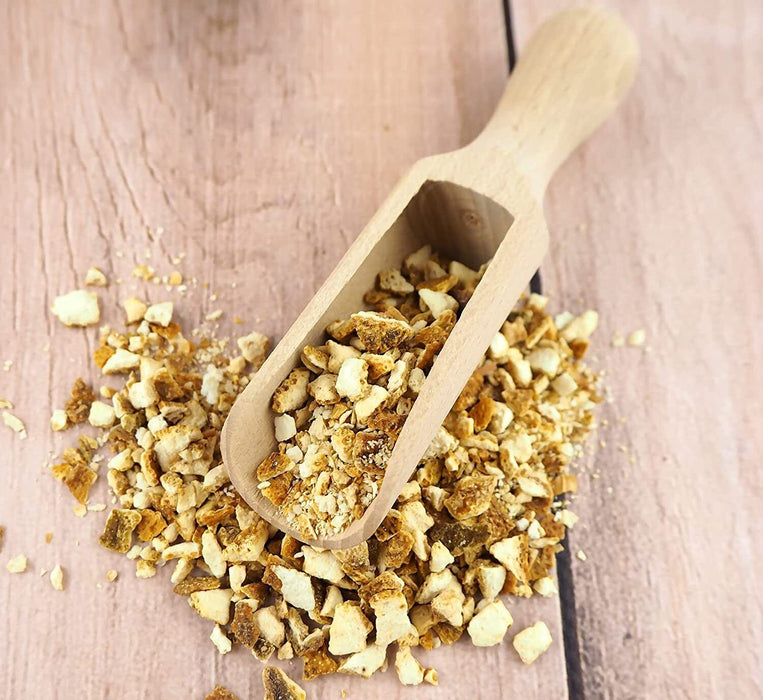 Pelle en bois remplie d'écorces d'orange amère séchées coupées, idéales pour les recettes de pâtisserie.