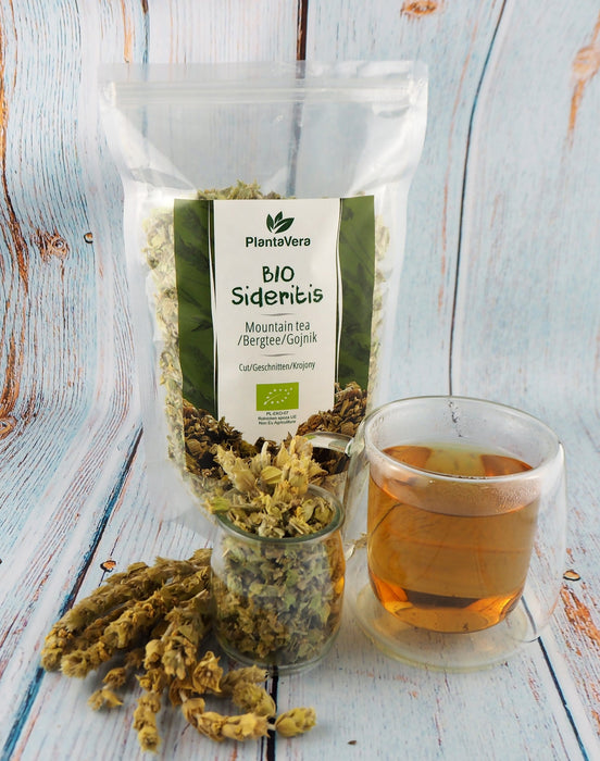 Packaging transparent avec Thé de montagne BIO Sideritis et une tasse d'infusion en arrière-plan, évoquant naturalité et fraîcheur.